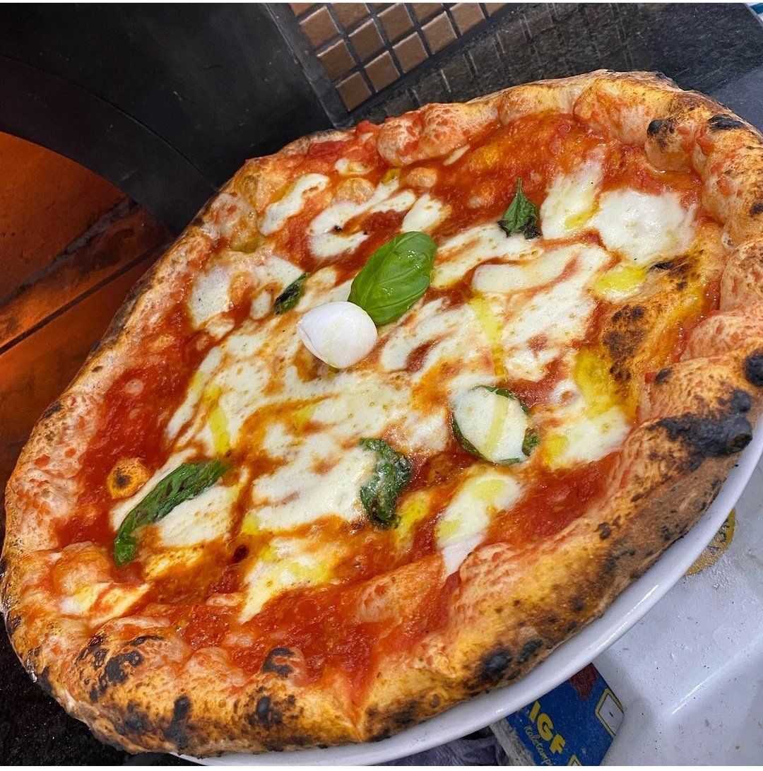 Una pizza con salsa di pomodoro e formaggio su un piatto bianco