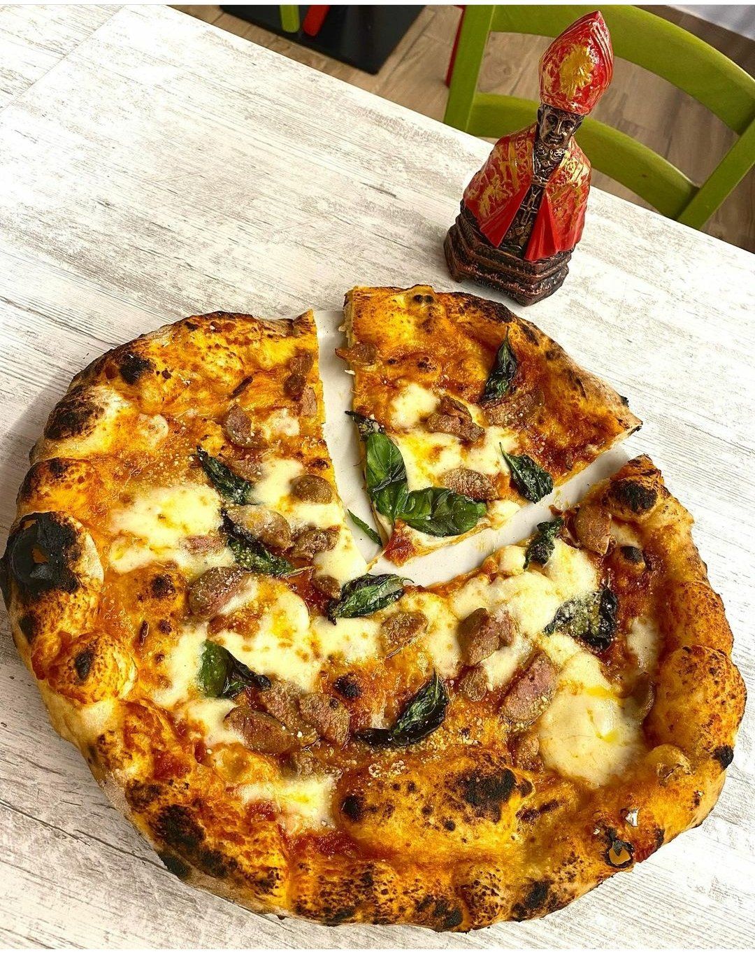 Una pizza da cui è stata tolta una fetta è appoggiata su un tavolo.