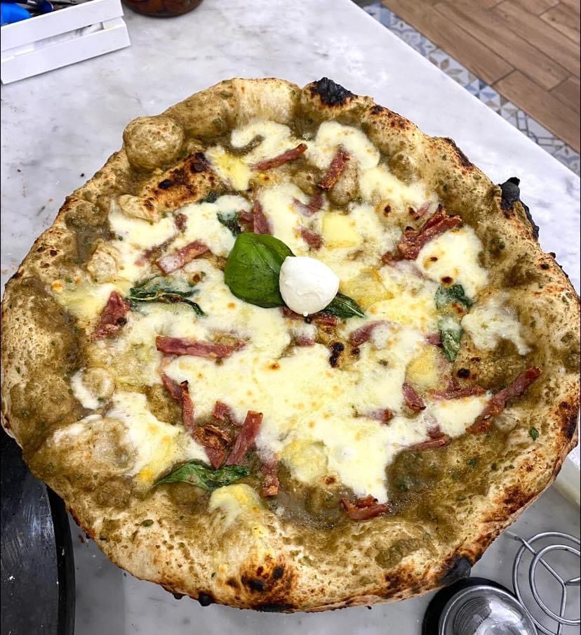 Una pizza con tanti condimenti è su un tavolo