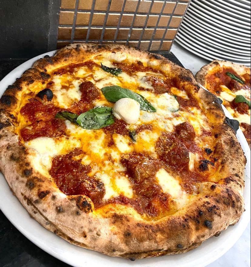 Una pizza con salsa di pomodoro e formaggio su un piatto bianco