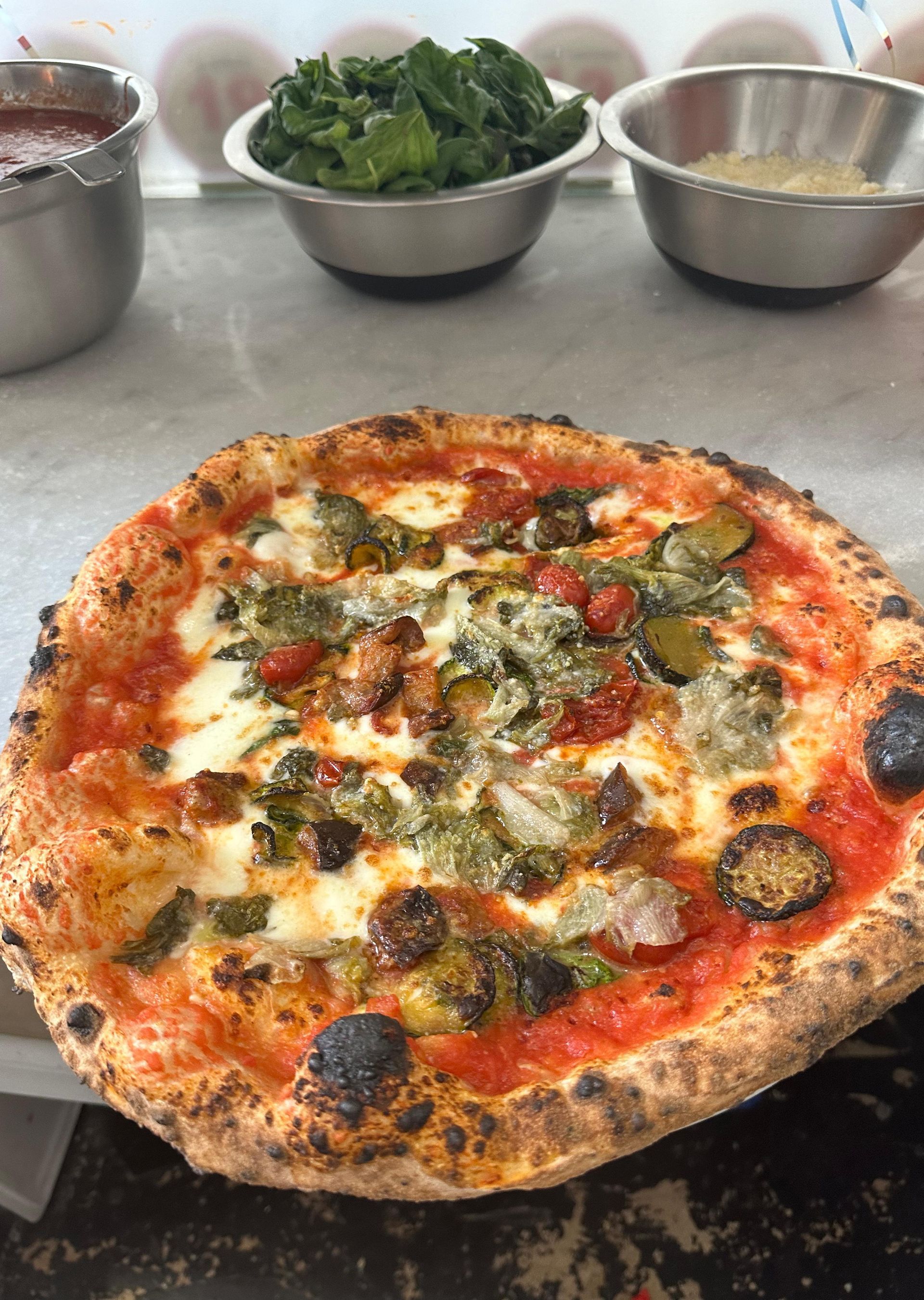 Una pizza con verdure appoggiata su un tavolo.