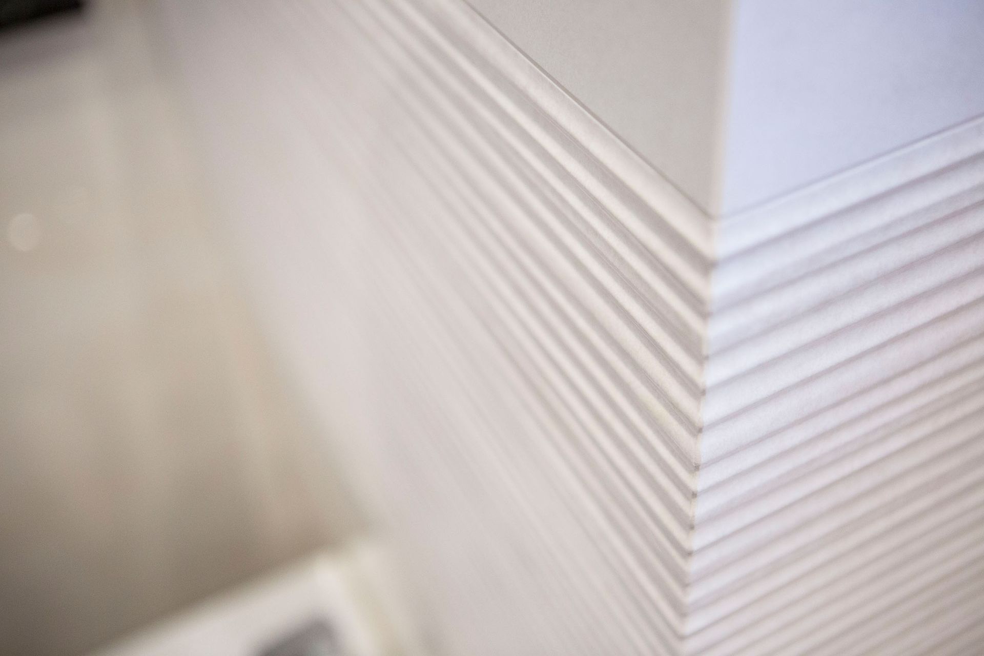 Eine Nahaufnahme einer weißen Zierleiste aus Fliesen an einer Wand.