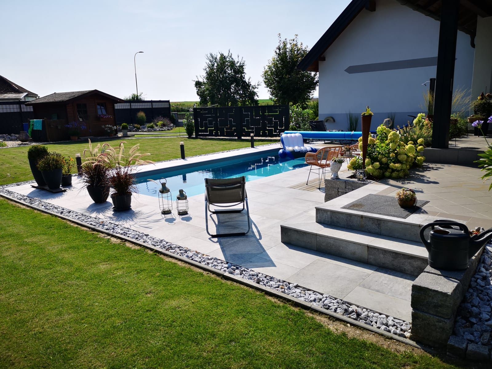 Im Hinterhof eines Hauses befindet sich ein großer Swimmingpool.