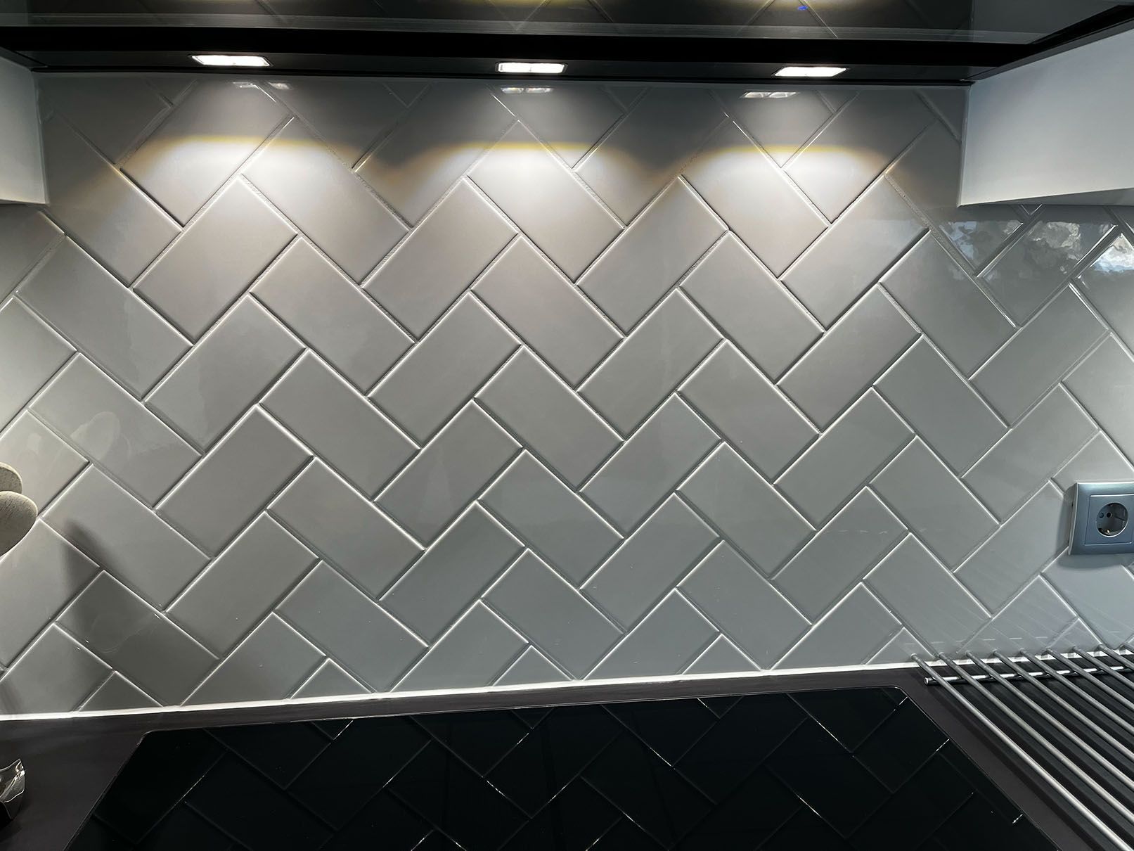 Eine Küche mit grauen Fliesen im Fischgrätenmuster