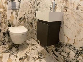 Ein Badezimmer mit Toilette, speziellen Fliesen und Waschbecken.