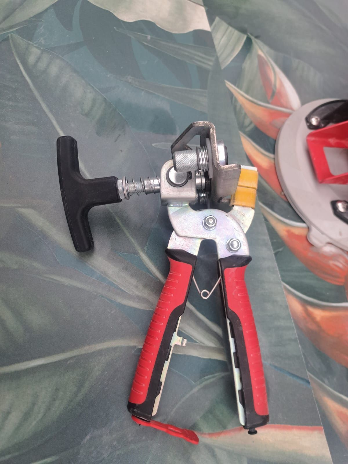 Eine rot-schwarze Zange mit schwarzem Griff