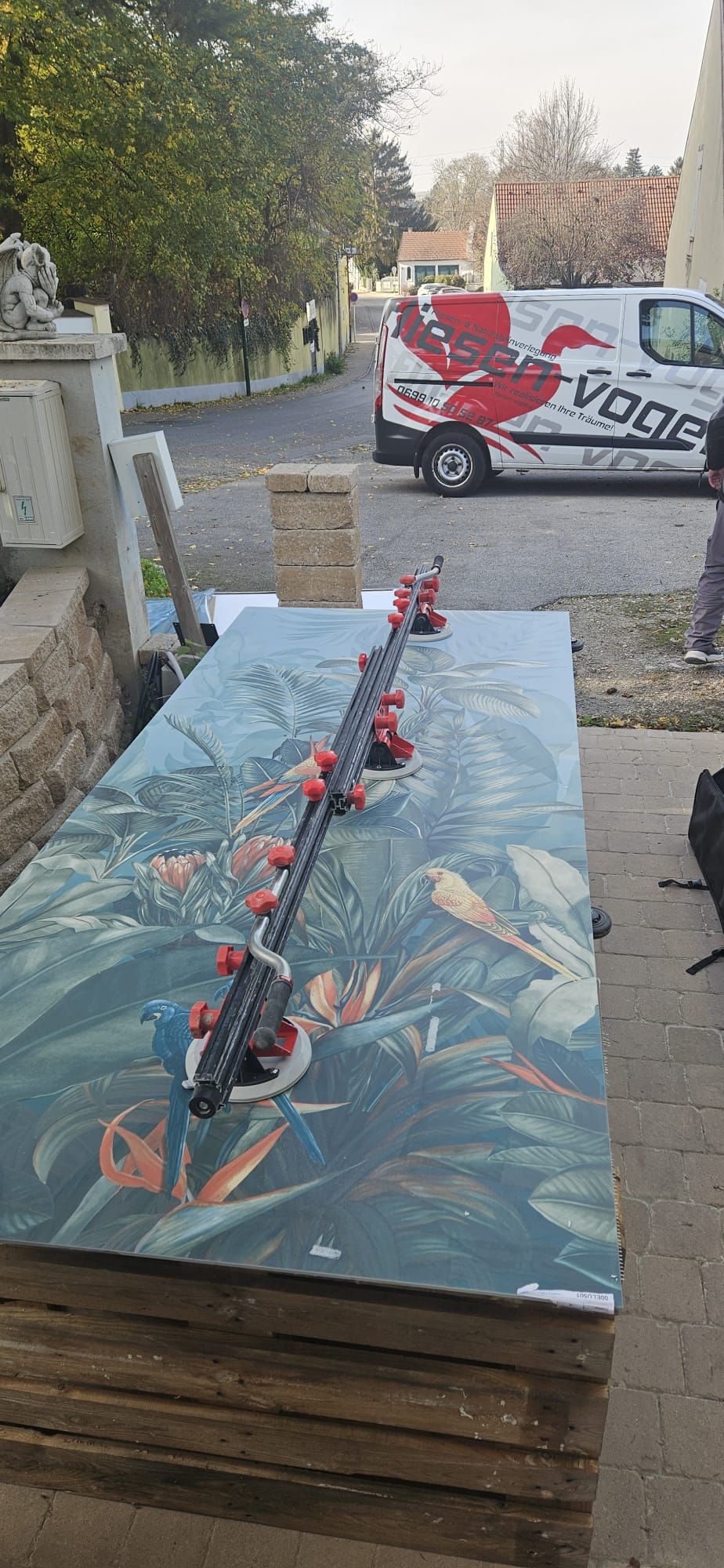 Auf einem Holztisch neben einem Lieferwagen steht eine Fliese.