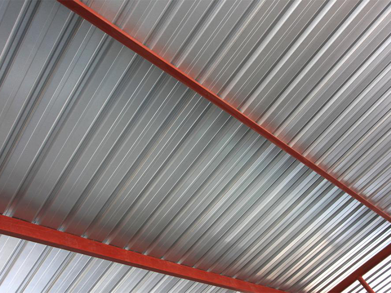 A close up of a metal roof with red beams