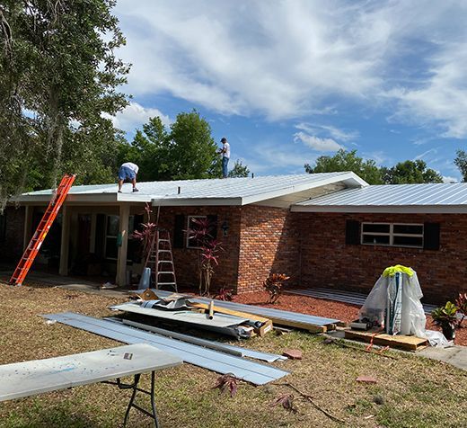 A man is standing on the roof of a house.