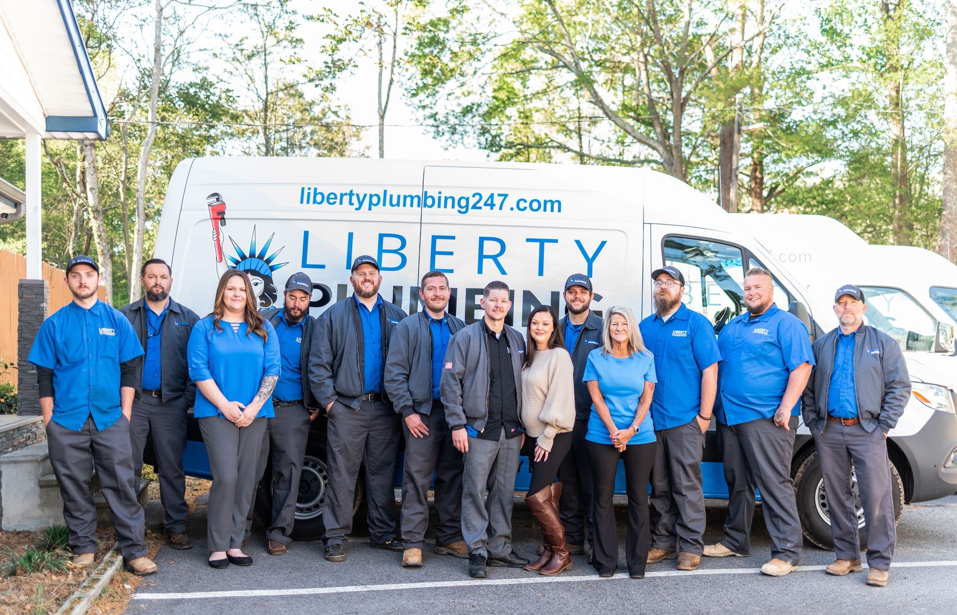 A group of people are posing for a picture in front of a van.