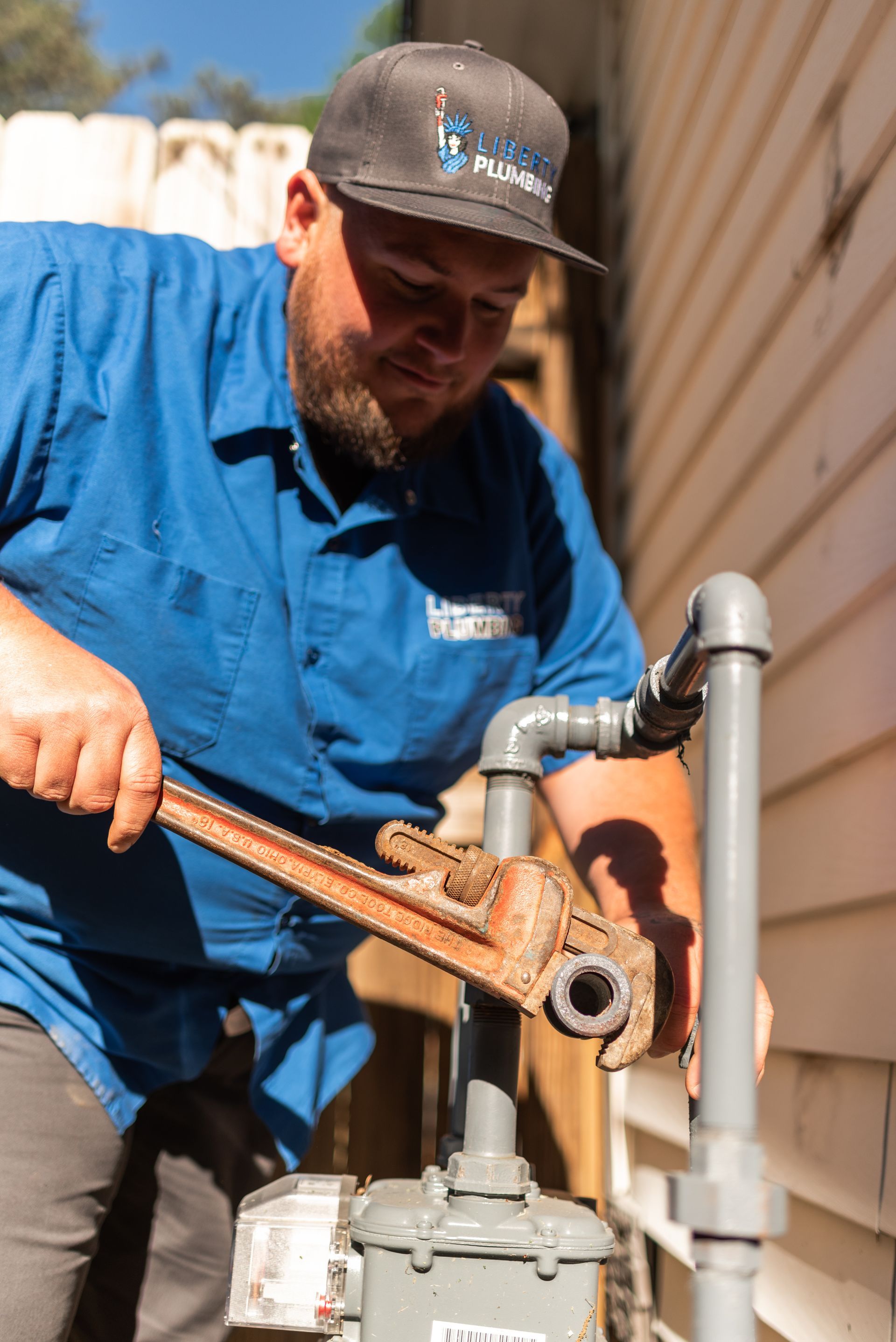 A man is fixing a gas meter with a wrench.