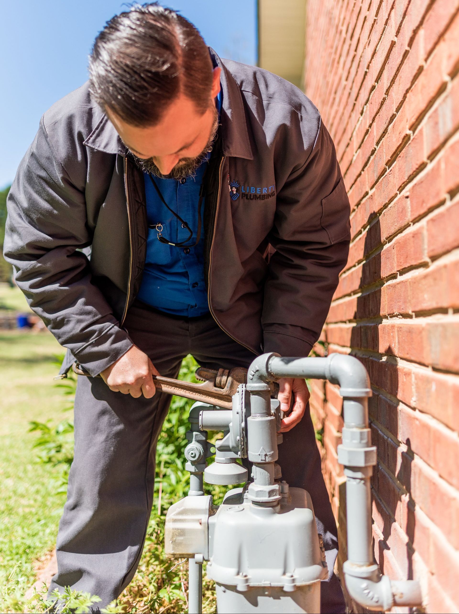 A person is working on a pipe in the dirt.