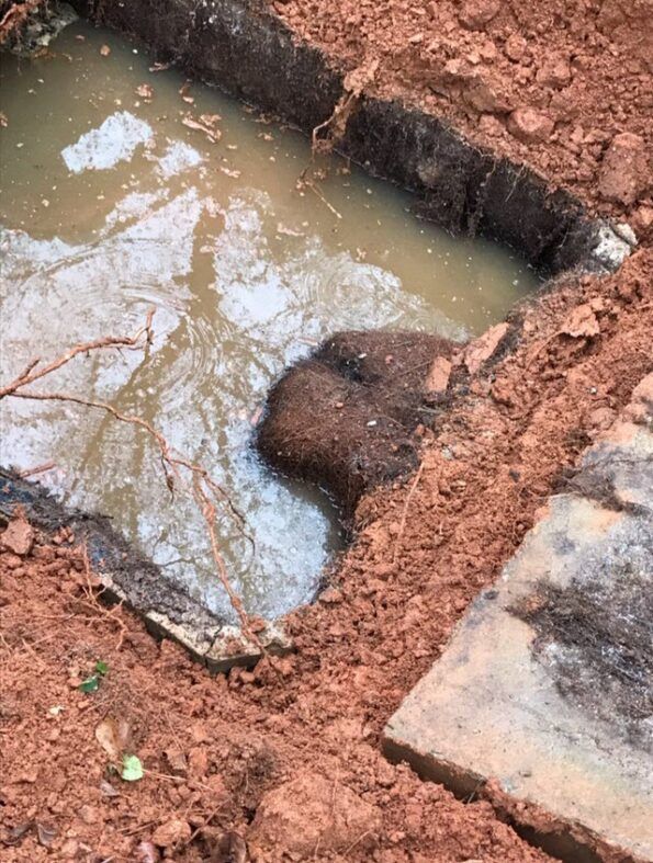 A large rock is laying in a puddle of water.