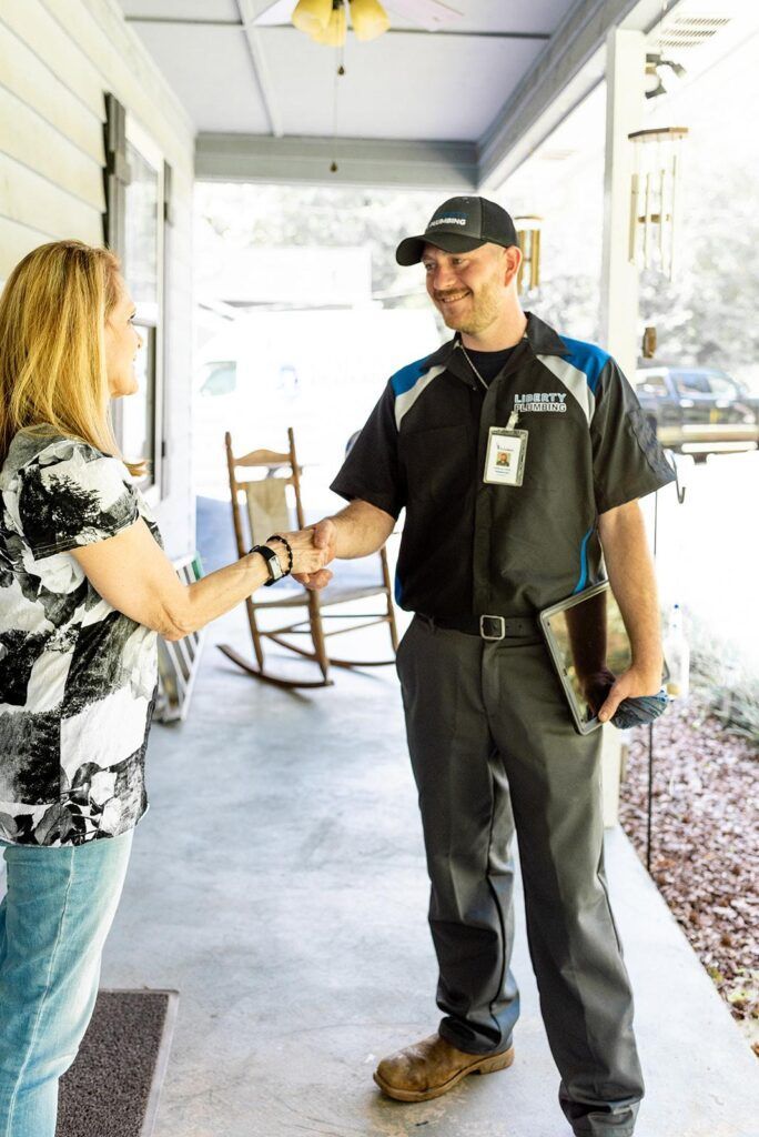 A man is shaking hands with a woman on a porch.