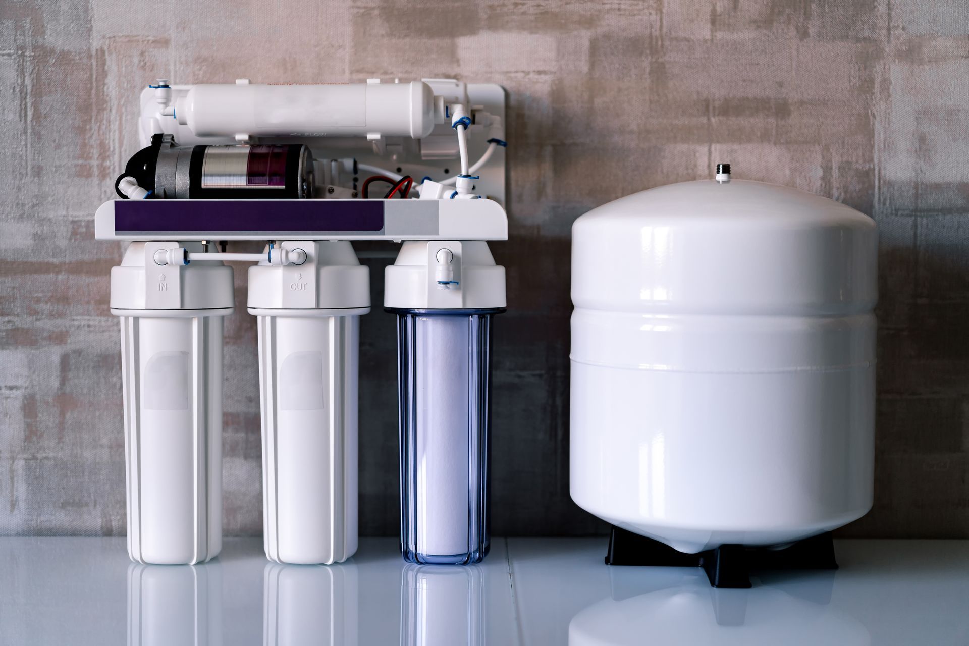 A water filter is sitting on a table next to a tank.