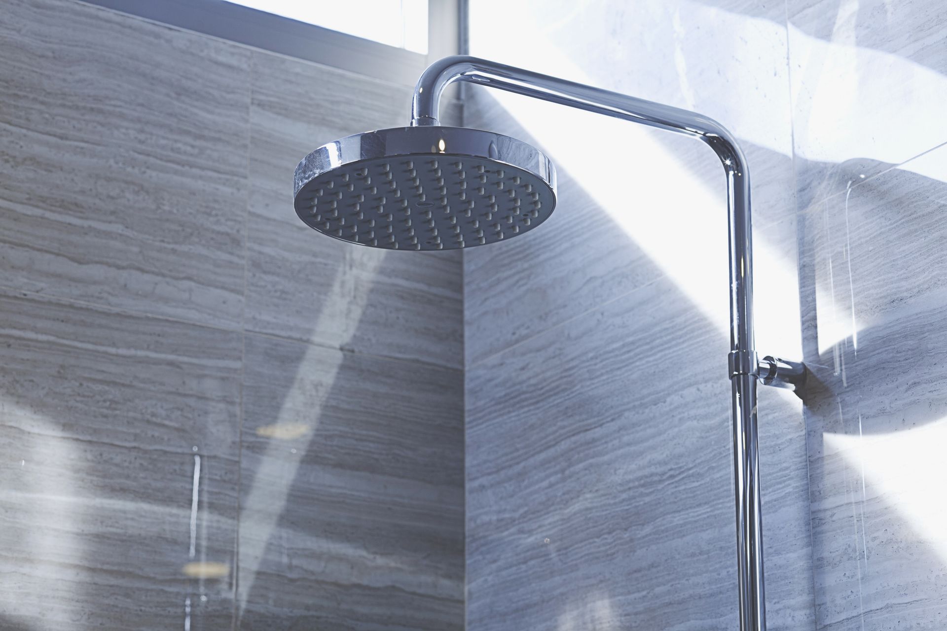 A close up of a shower head in a bathroom