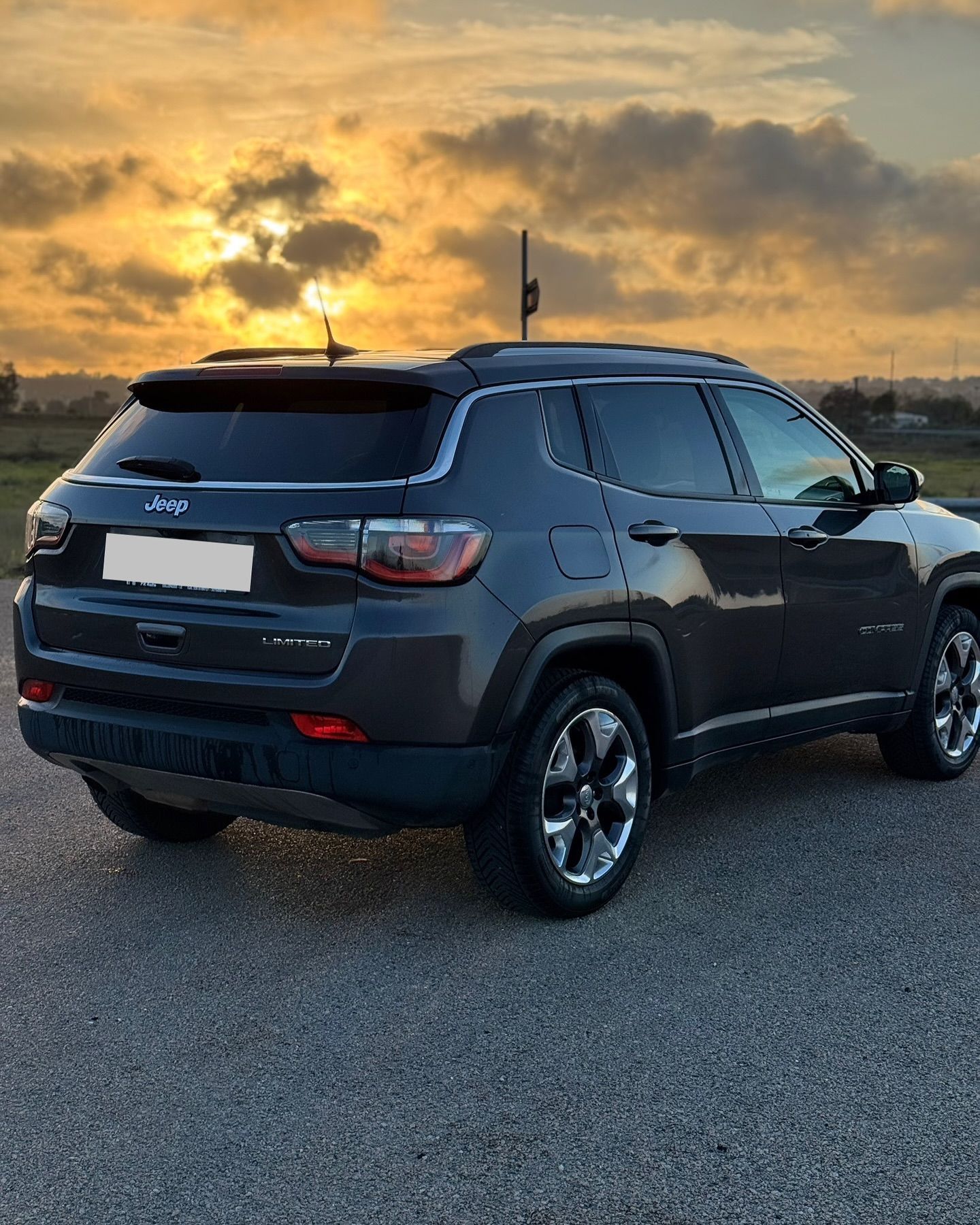 una persona tiene in mano le chiavi davanti a un'auto.