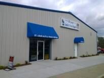 A tan building with a blue awning over the entrance | St. Louis Auto & Truck Repair