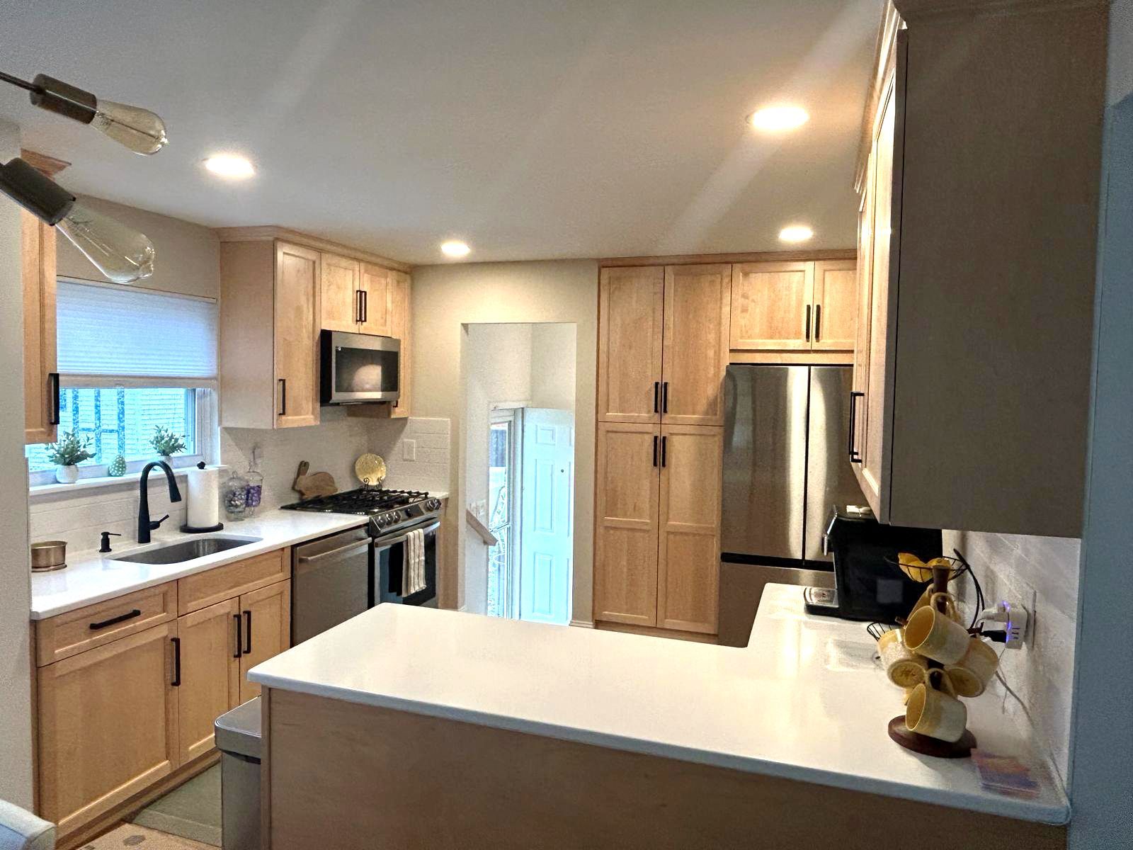 remodeled kitchen with wooden cabinets and marble countertops