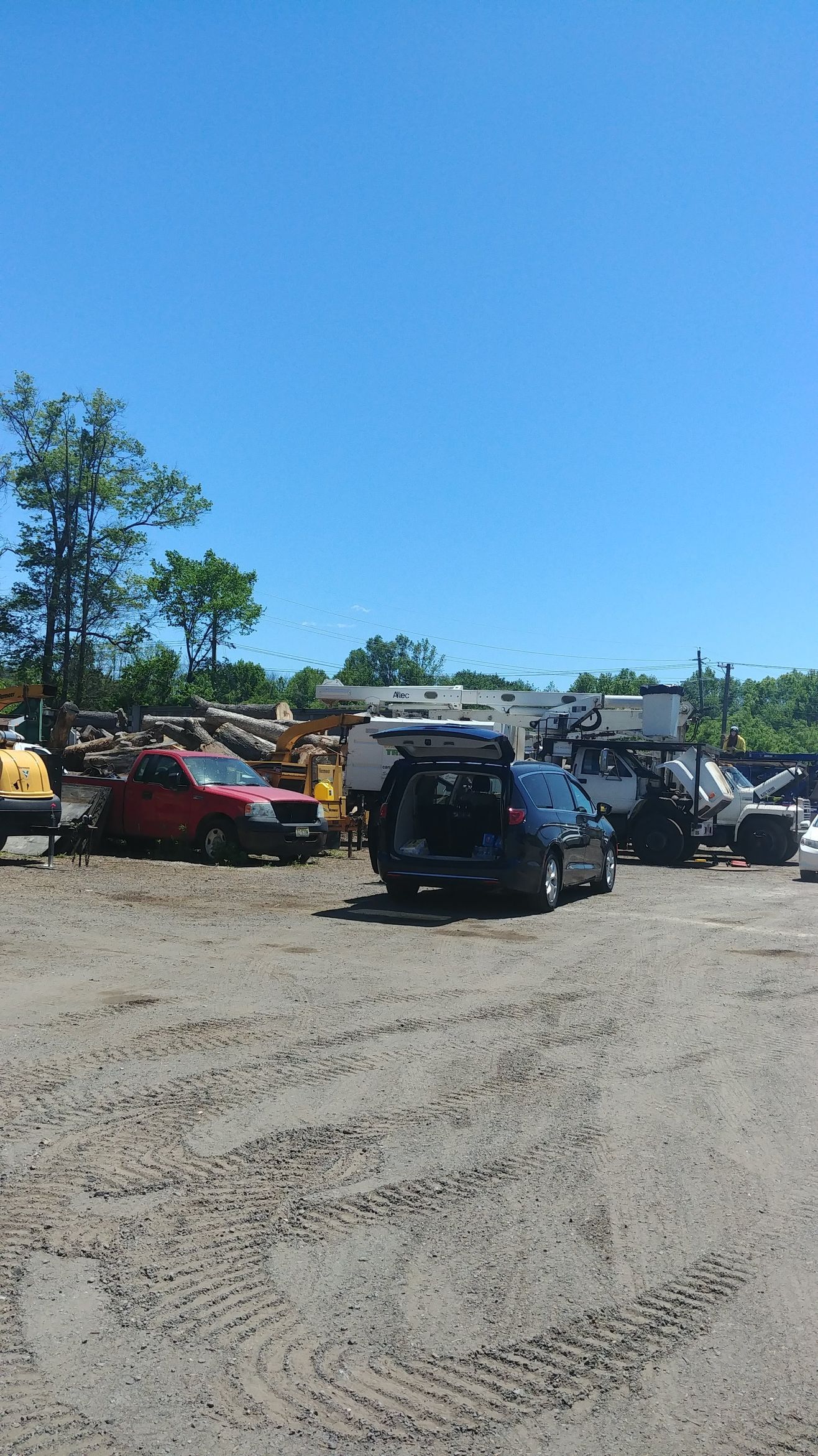 A Row of Cars Are Parked in A Dirt Lot – Lawrence Township, NJ – Carroll Tree Service