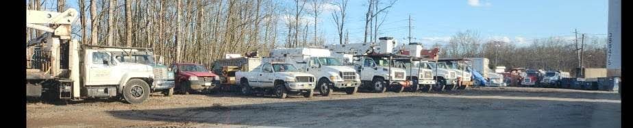 A Row of Trucks Are Parked on The Side of The Road – Lawrence Township, NJ – Carroll Tree Service