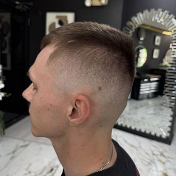 A man is getting his hair cut in a barber shop.