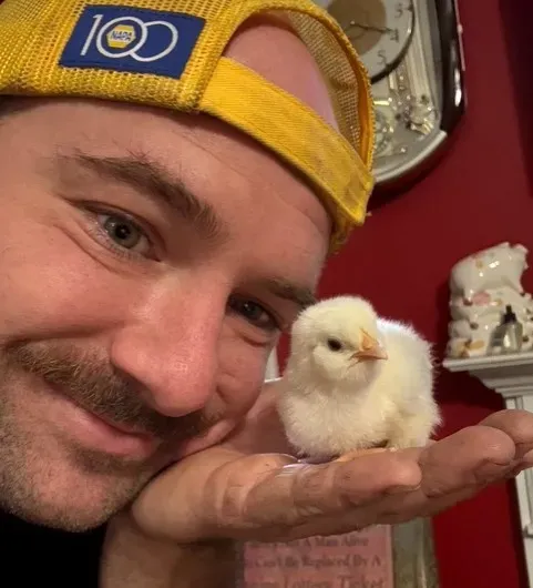 Derek holding a small baby chick | Gary's Automotive Again