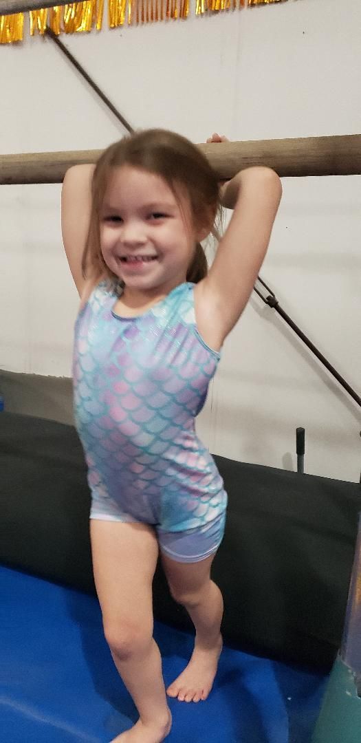 A group of children are celebrating a birthday with a cake and presents