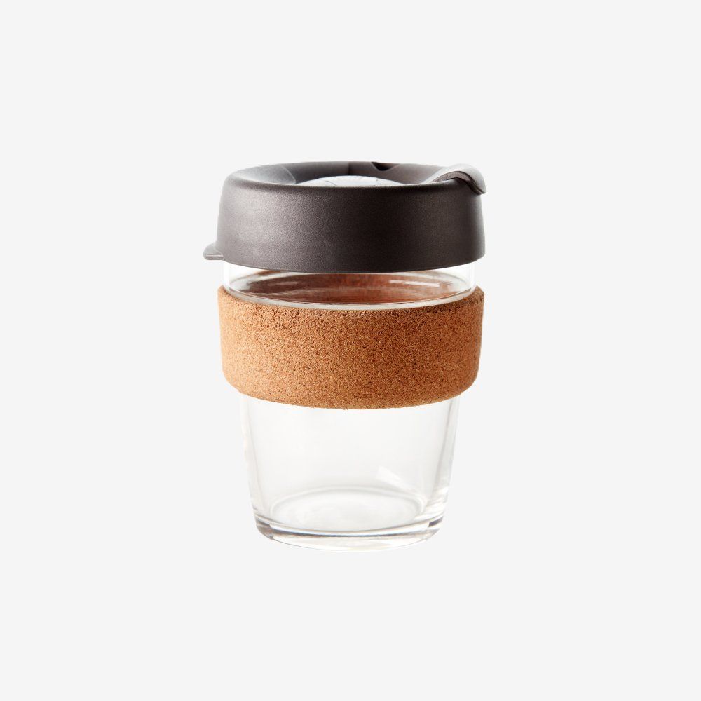 Clear glass reusable cup with a cork sleeve and dark gray lid