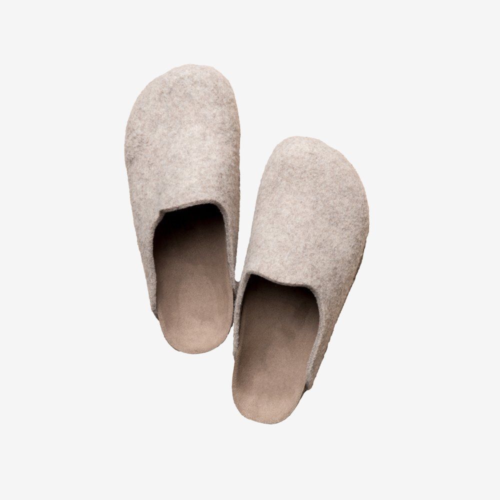 Pair of light gray fuzzy slippers on a white background