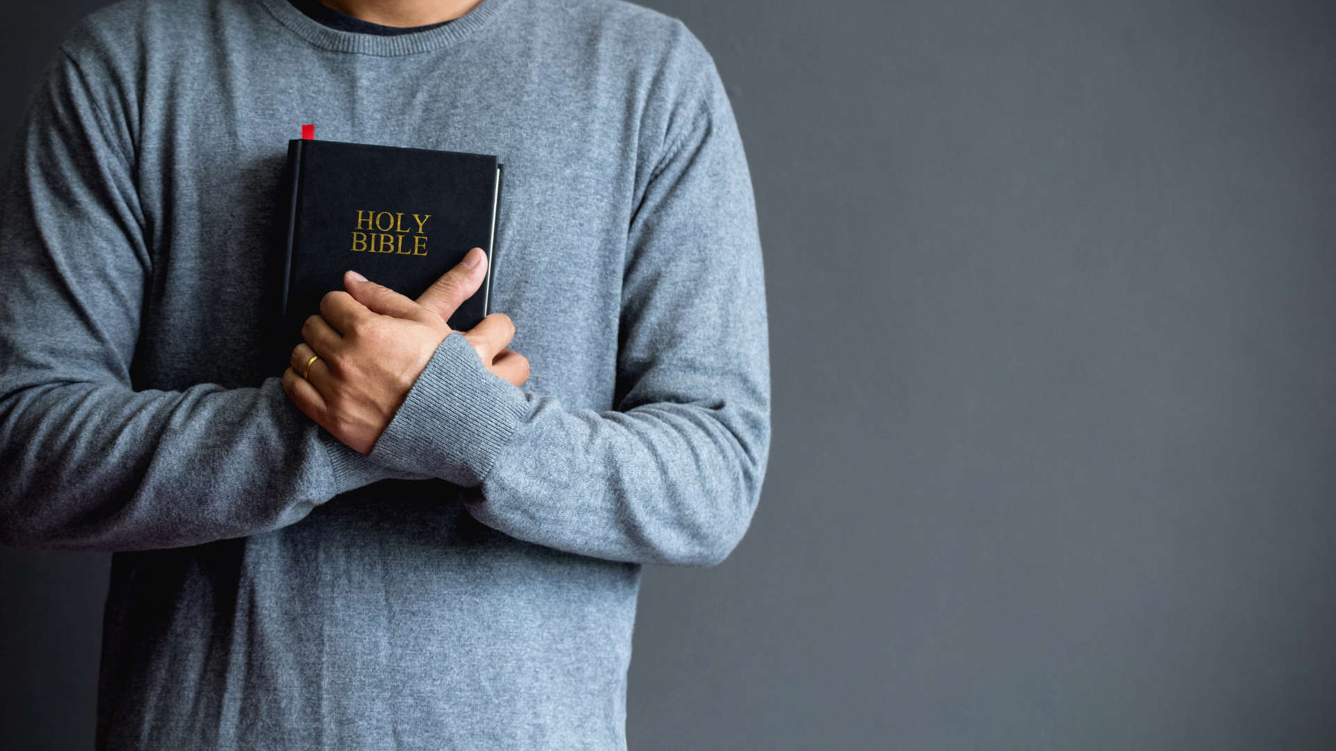 A man is holding a bible in his hands.