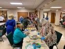A group of people are sitting at a long table in a room.