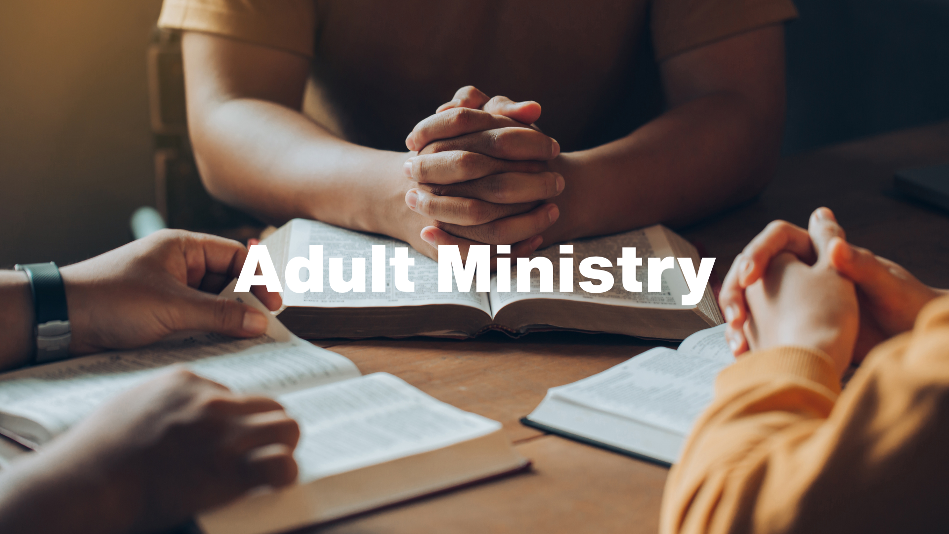 People with hands clasped over open books,