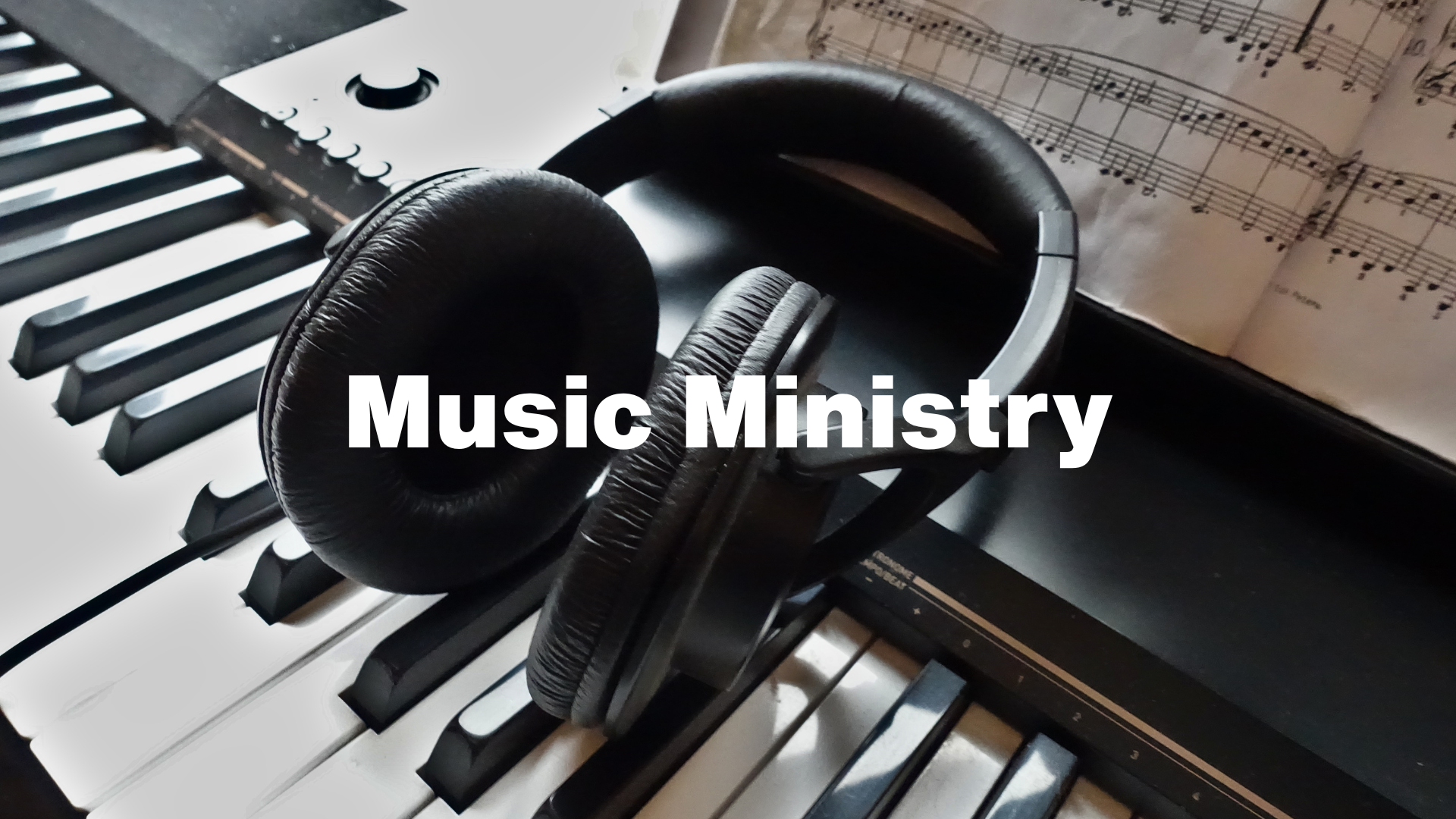 Headphones resting on a piano keyboard with sheet music in the background; text