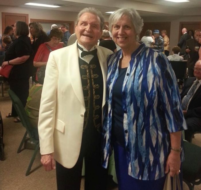 A man and woman pose for a picture in a crowded room