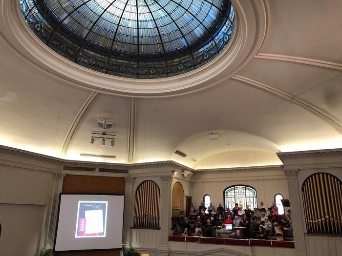 A large room with a dome ceiling and a projector screen.