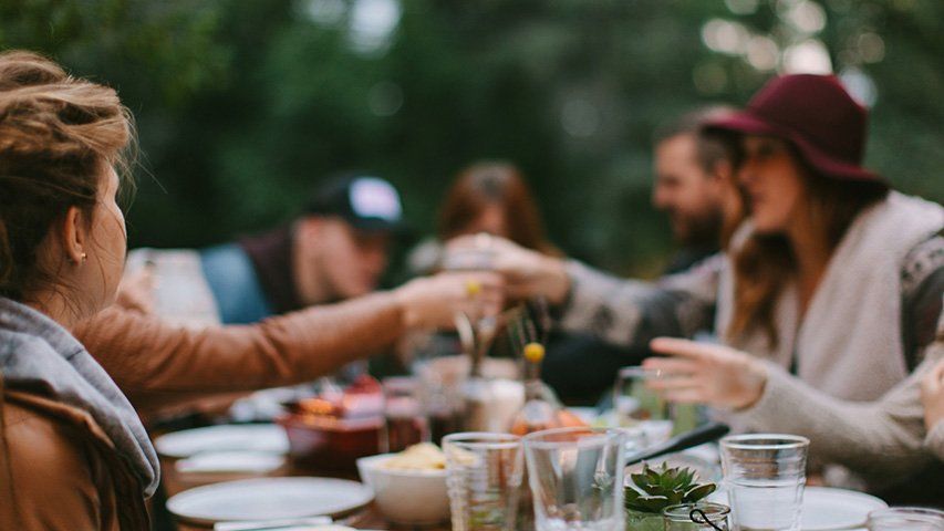 A group of people are sitting at a table eating food.