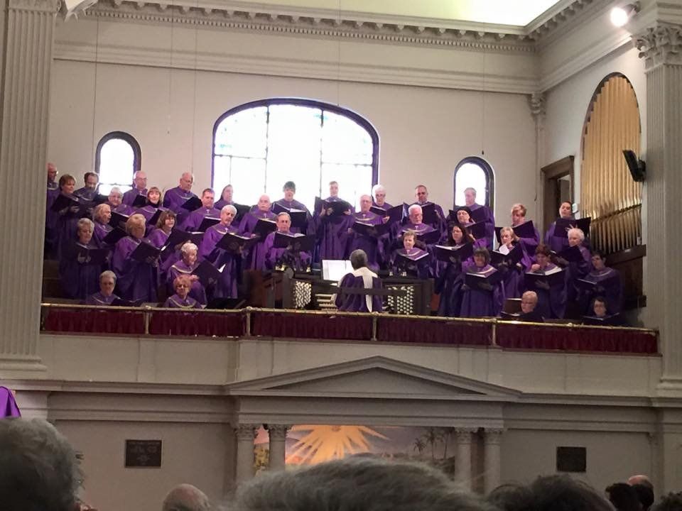 A large choir is singing in a church