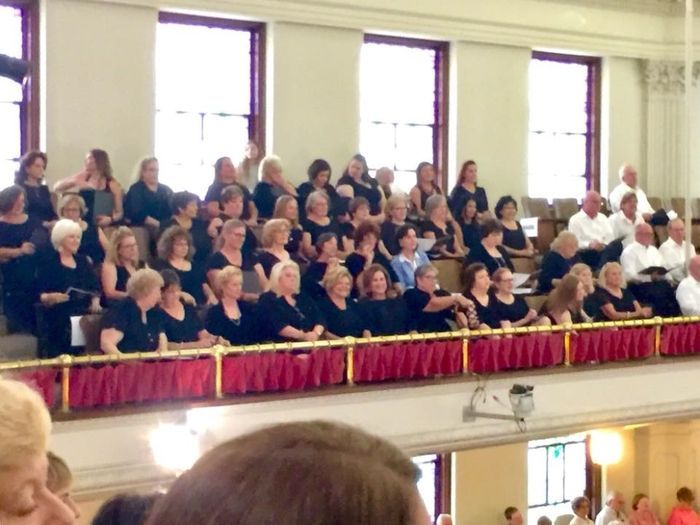 A large group of people are sitting on a balcony