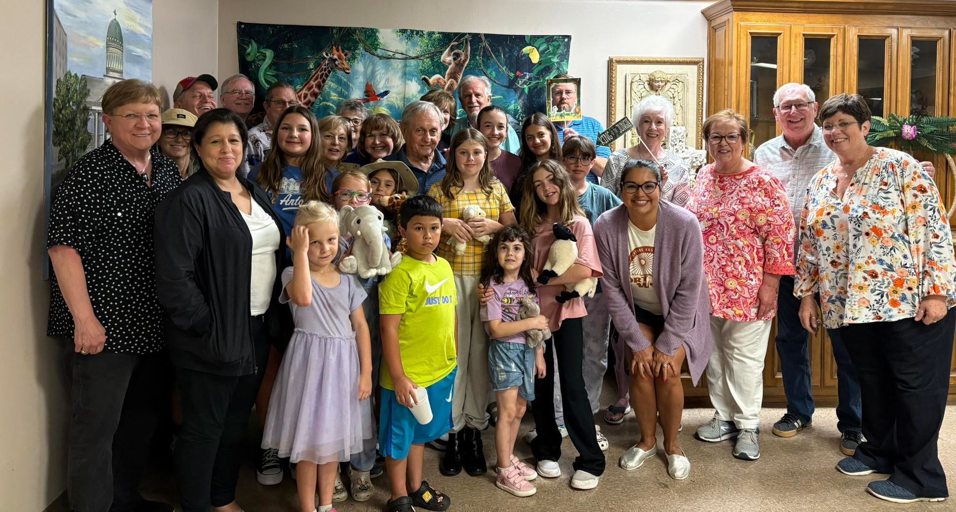 Group of people posing together indoors, smiling.