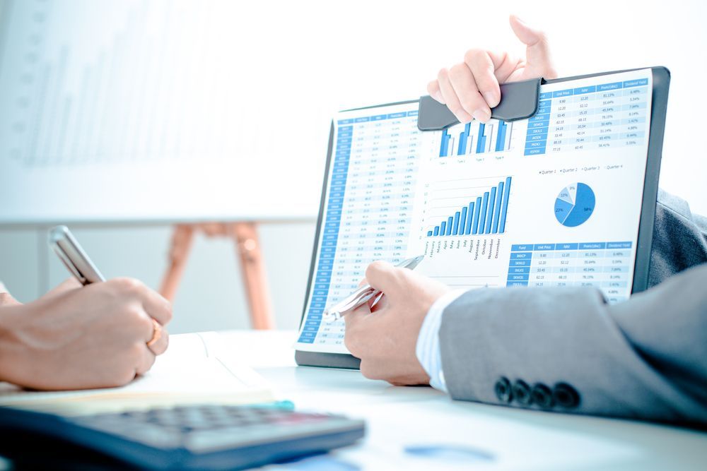 Two People Reviewing Financial Charts and Data on a Clipboard — Precision Financial & Tax In Ross Creek, VIC