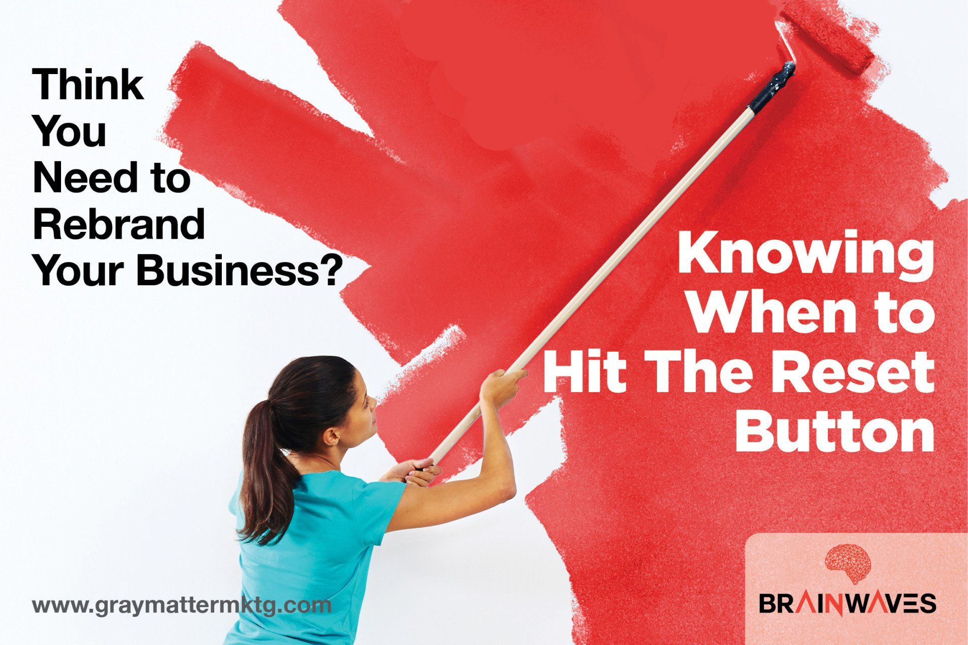 A woman is painting a red wall with a roller.