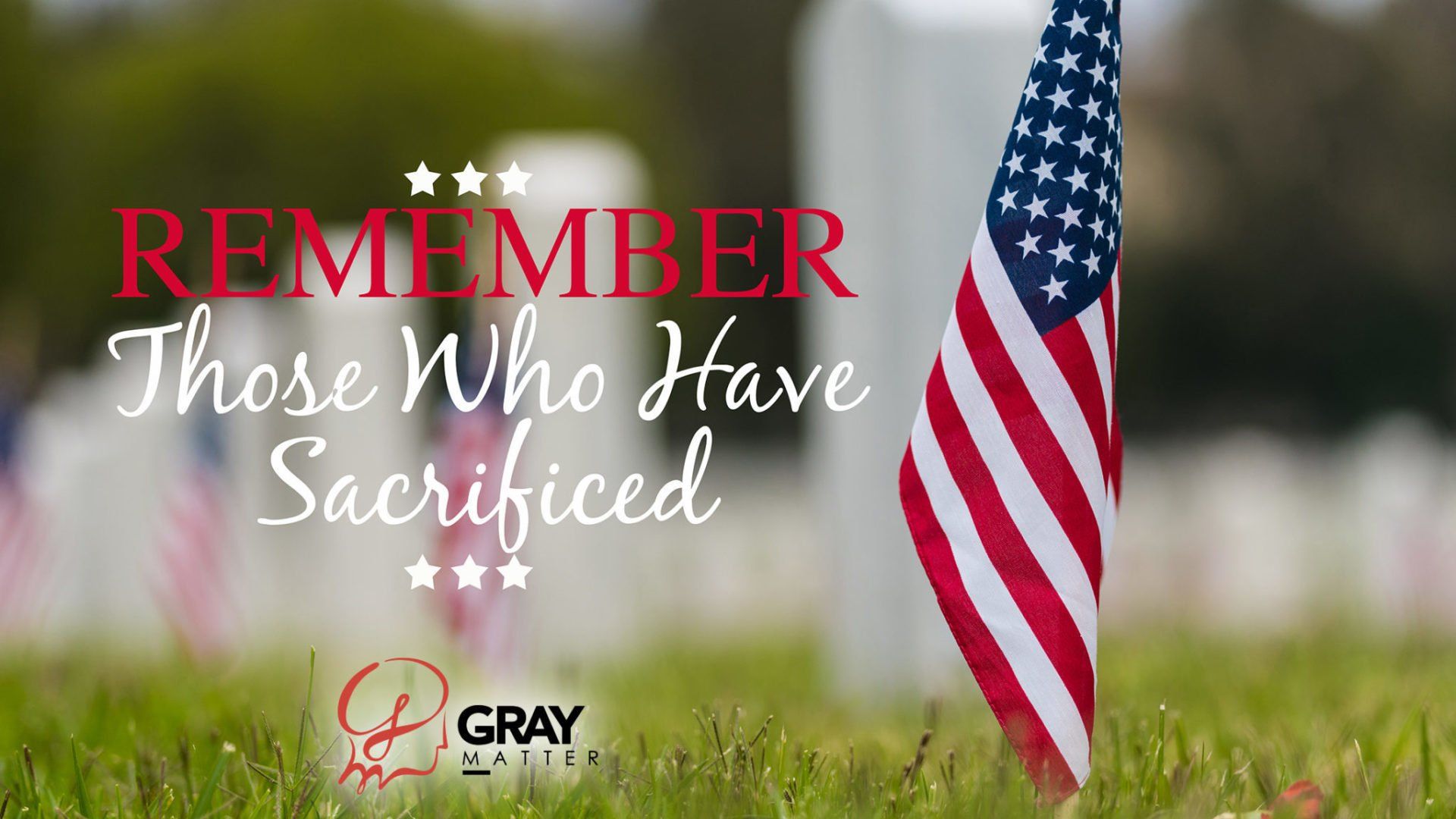 An american flag is in the grass with the words `` remember those who have sacrificed '' written on it.