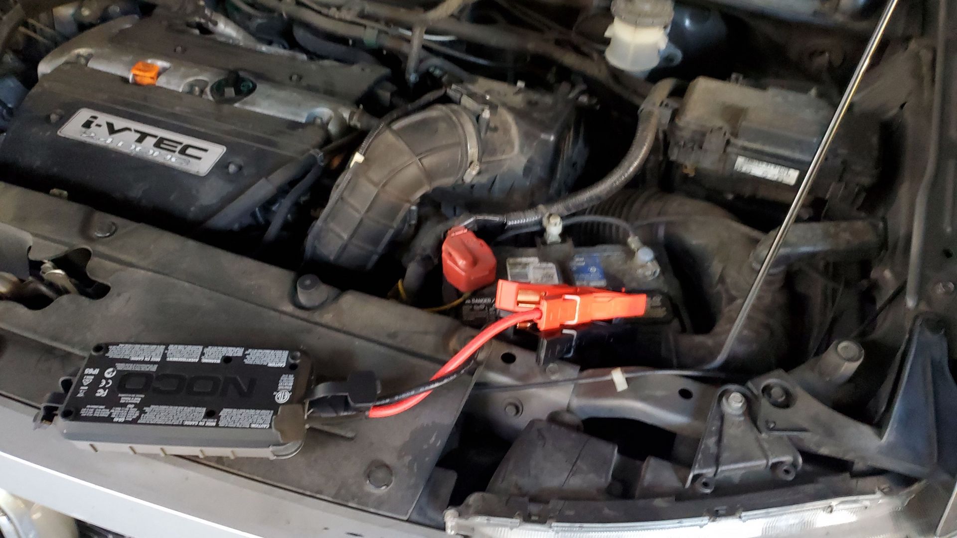 A car engine with a battery charger attached to it.
