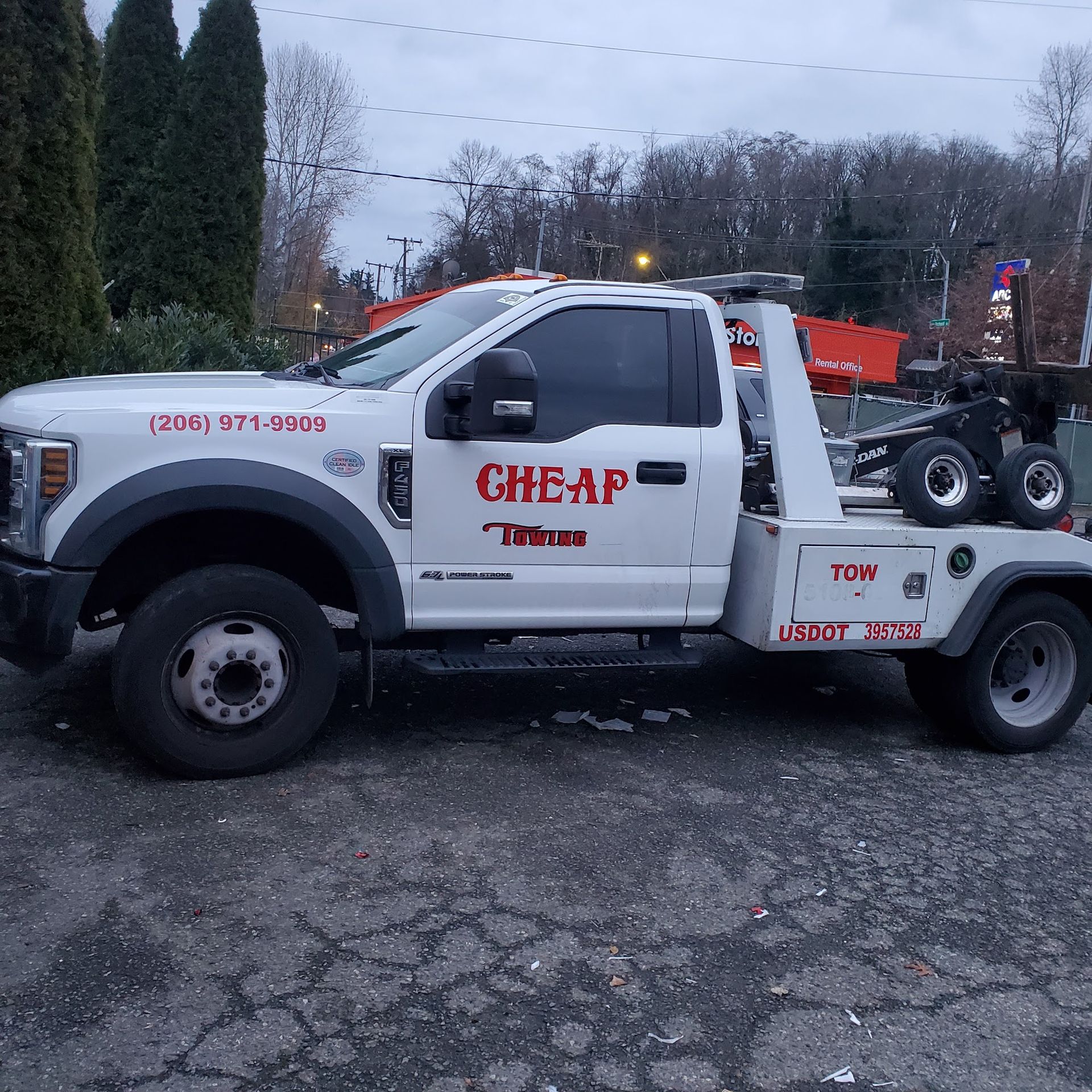 A cheap tow truck is parked in a parking lot