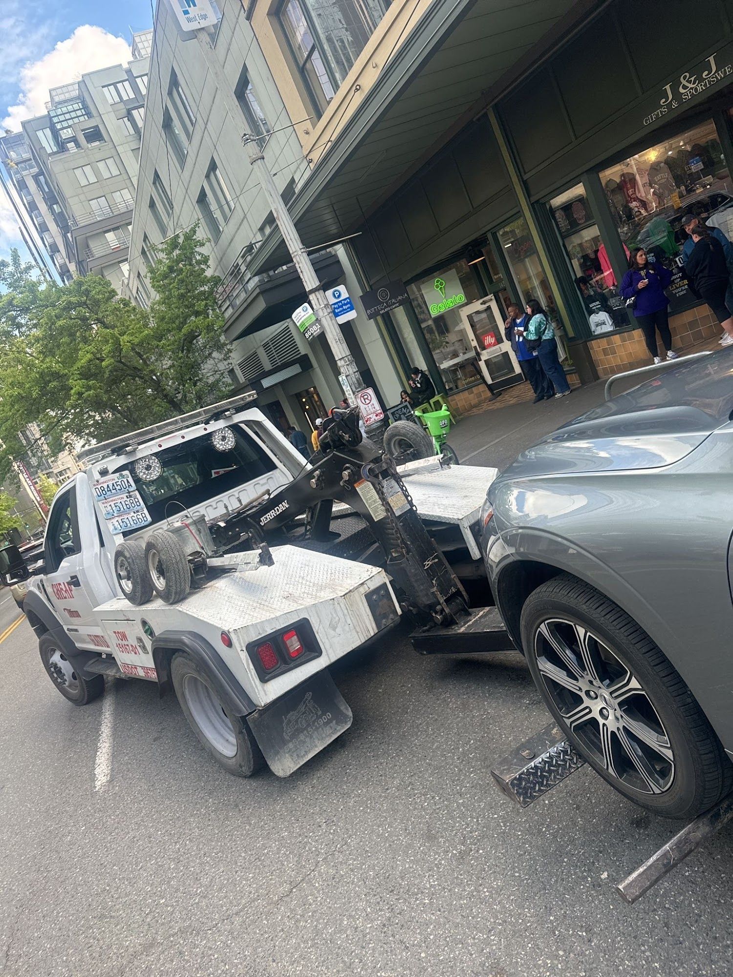 A tow truck is towing a car on the side of the road.