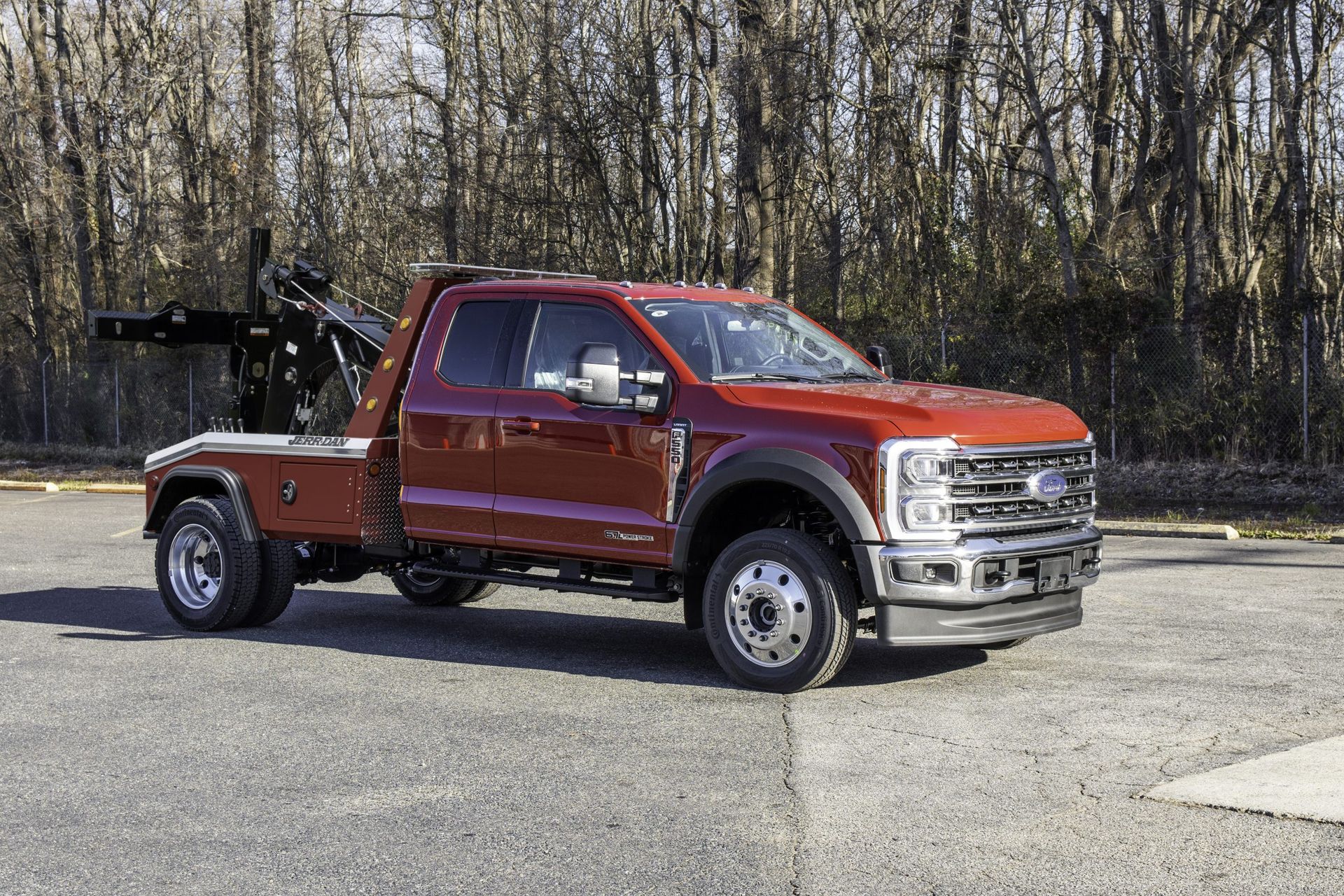 A red tow truck is parked on the side of the road.