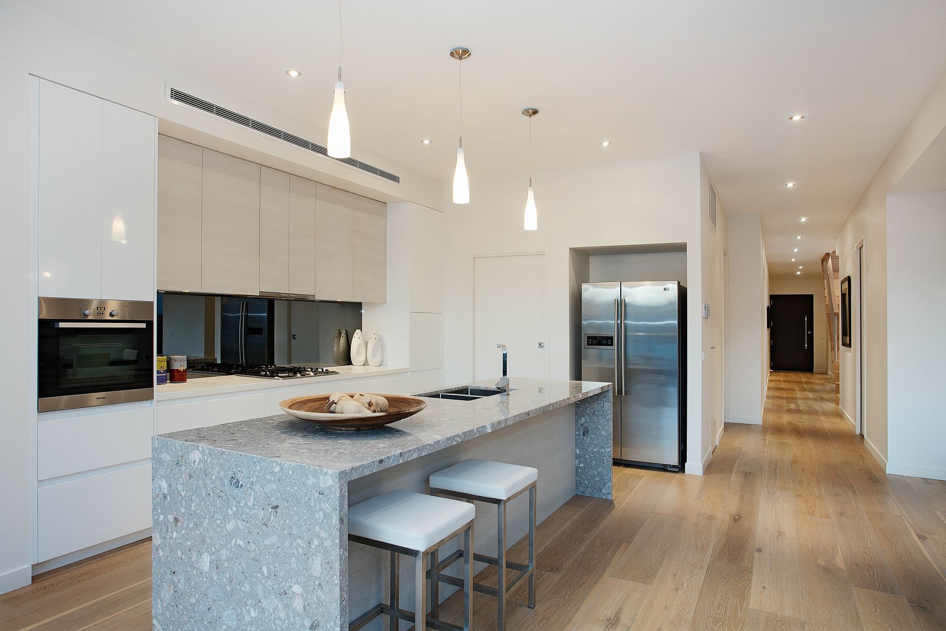 A Kitchen With White Cabinets And Stainless Steel Appliances — KM Custom Homes In Mount Eliza, VIC