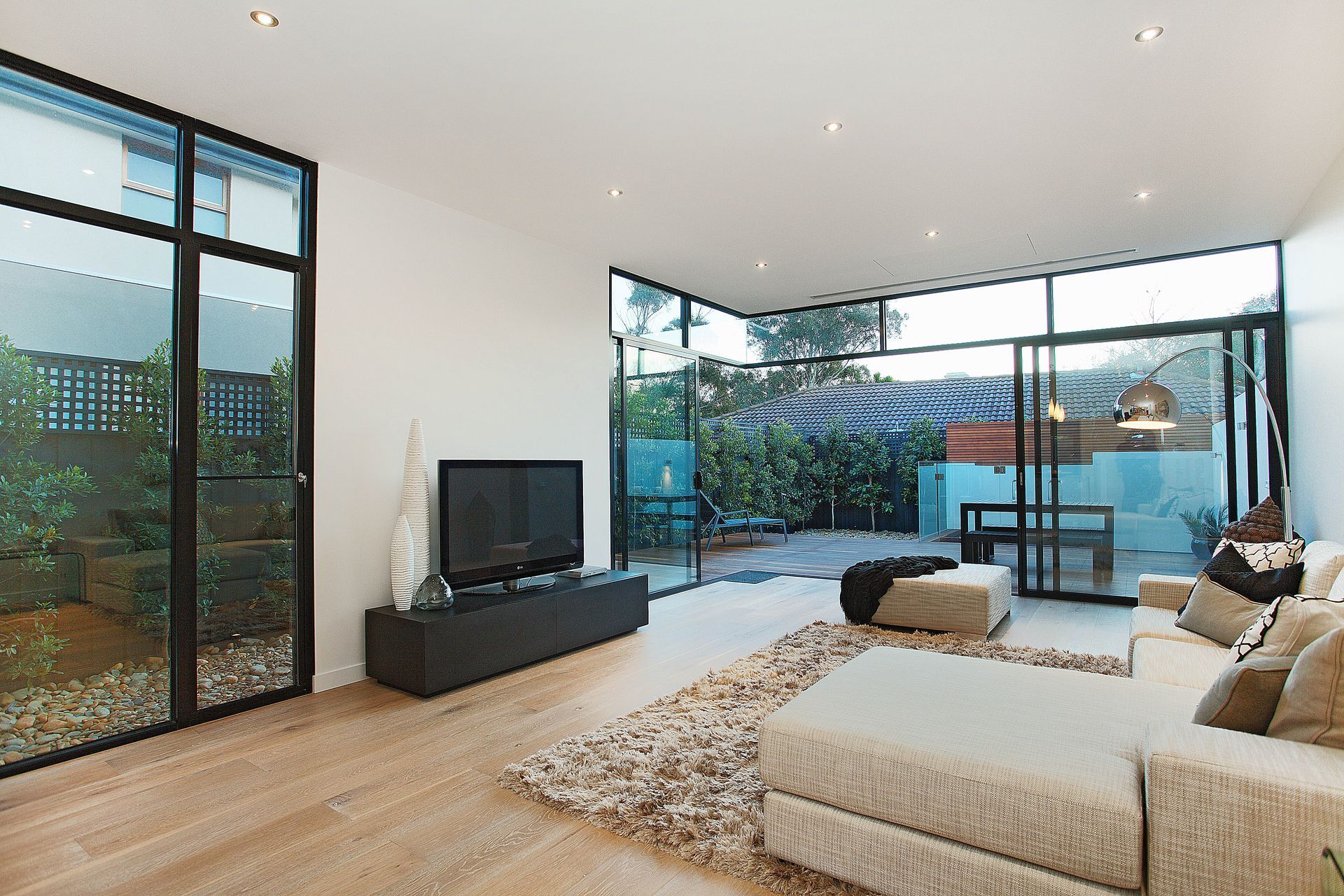 A Living Room With A Couch Television And Sliding Glass Doors — KM Custom Homes In Mount Eliza, VIC