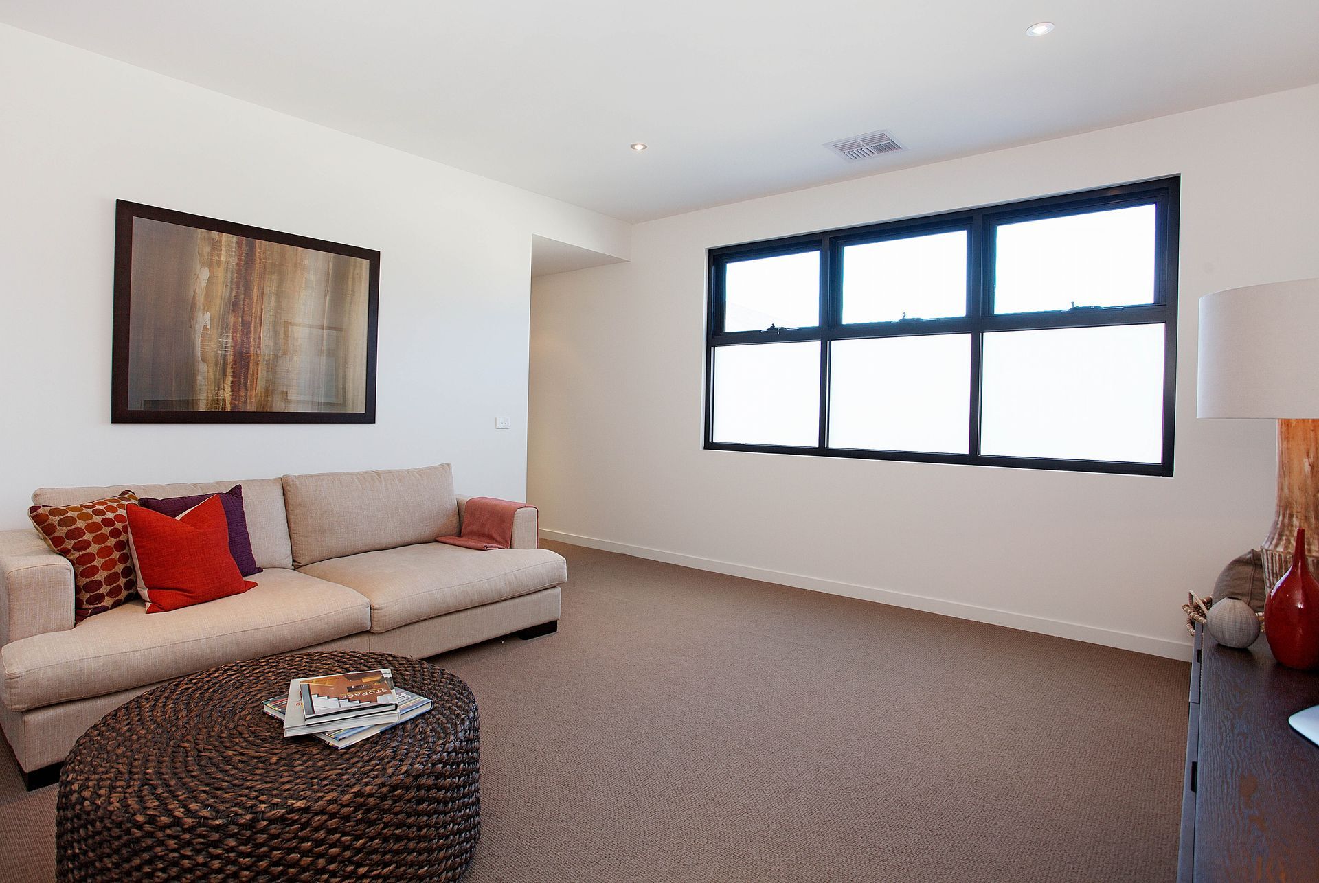 A Living Room With A Couch And A Round Coffee Table — KM Custom Homes In Mount Eliza, VIC